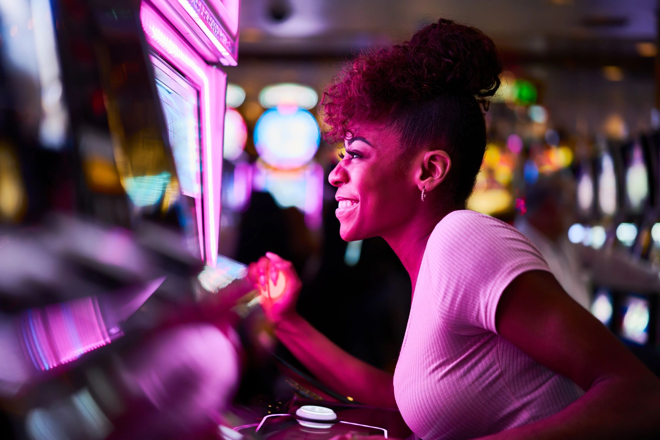 Woman having fun playing slot machine at casino